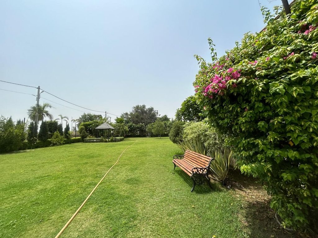 Lush green farmhouse in Lucknow featuring open lawns and peaceful natural surroundings